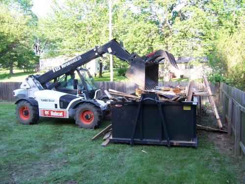 Loading a dumpster with a Bobcat