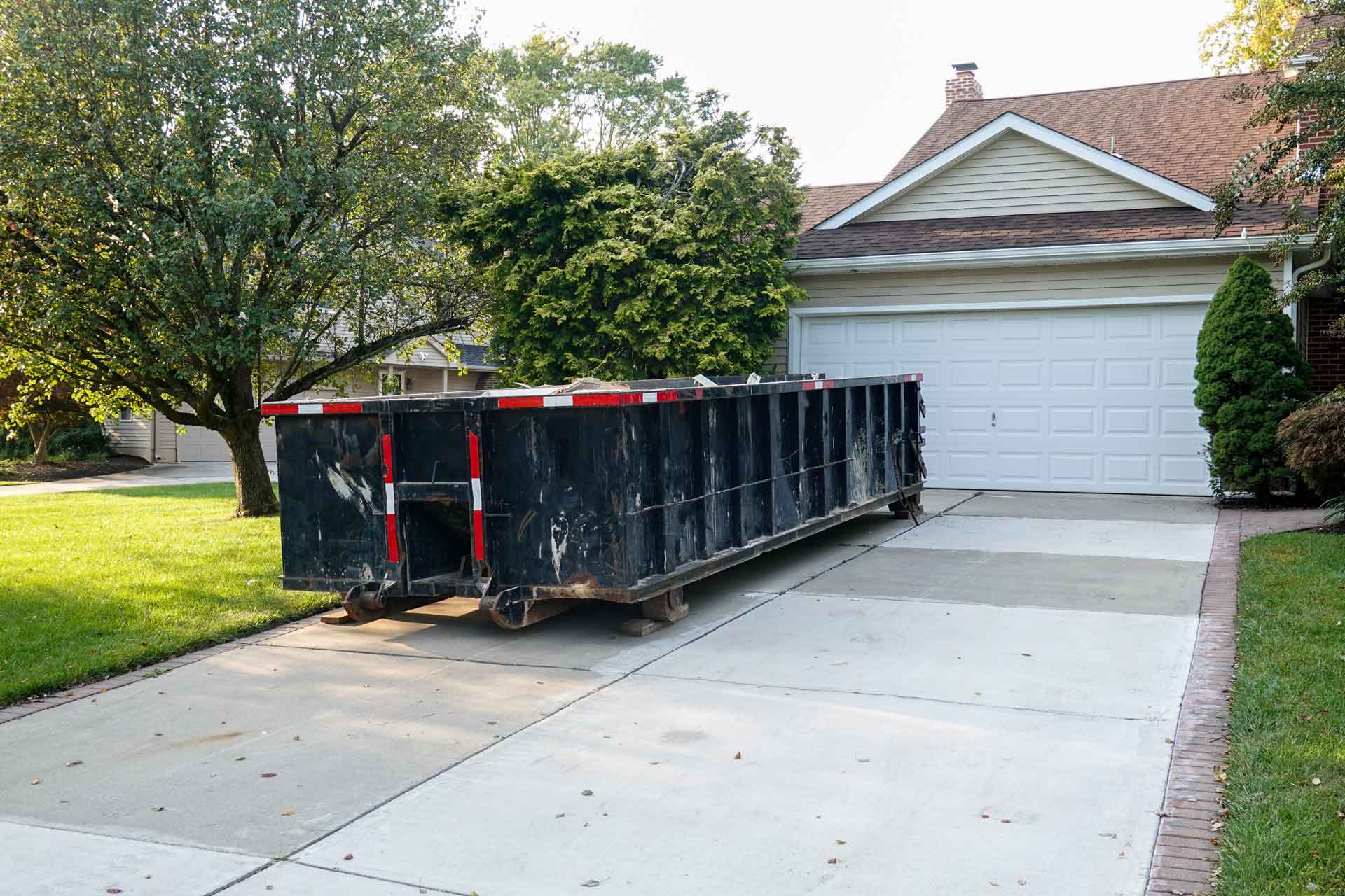 Rental dumpster sitting in a driveway