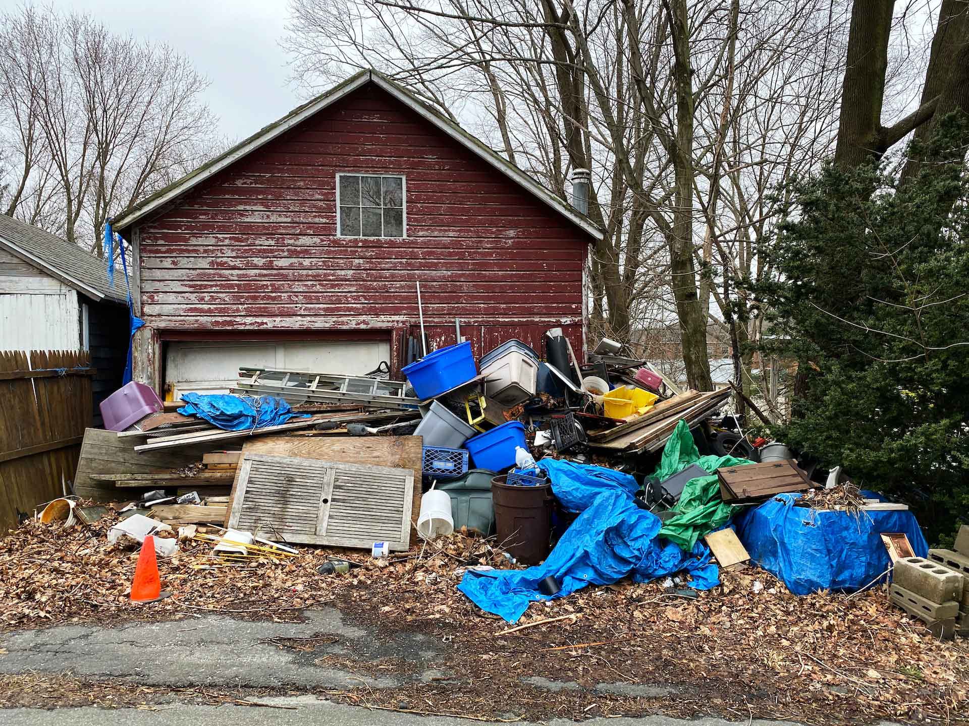 A pile of junk in front of a garage