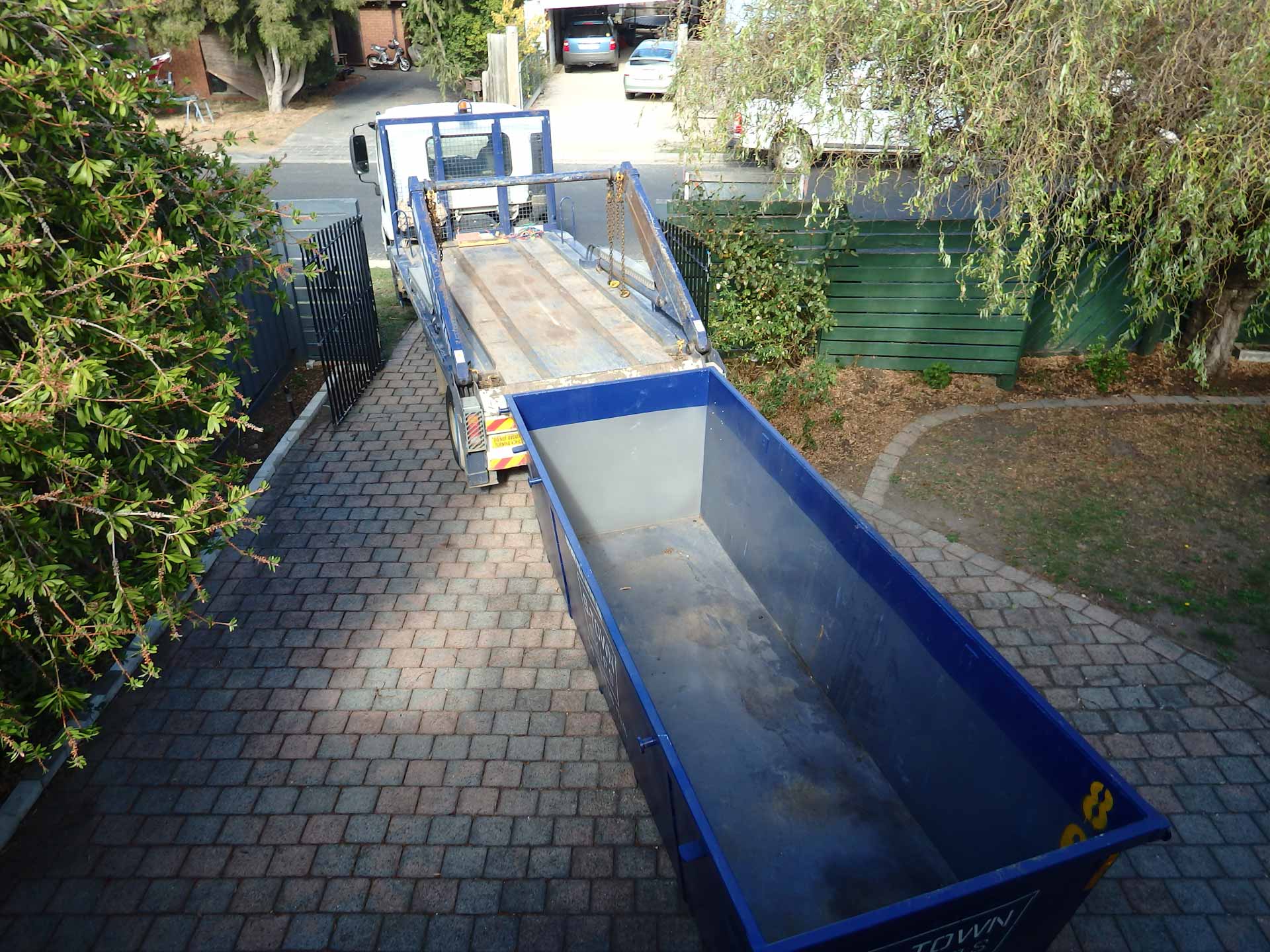 Blue rental dumpster in residential driveway